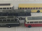 quatre petits bus alignés sur une table