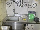 graffiti on the wall of a kitchen with a sink and a trash can
