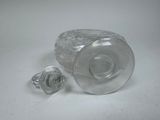 a glass bottle and a glass stopper sitting on a table