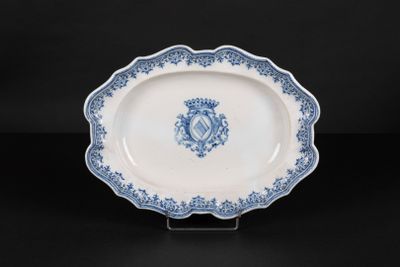 an antique blue and white platter with a crest on it