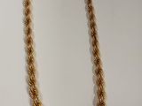 un collier en or sur fond blanc, avec une étiquette de prix