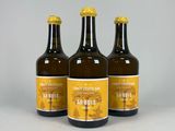 trois bouteilles de bière posées les unes à côté des autres sur une table