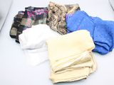 une pile de vêtements pliés sur une table blanche