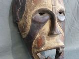 a wooden mask with a face that has been carved into it