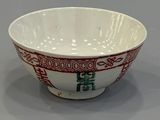 a white bowl with red and green designs on it