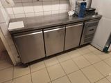 a stainless steel counter top in a kitchen with a refrigerator