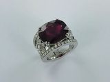 une bague ornée d'un gros rubis taille coussin entouré de diamants