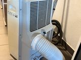 a small air conditioner sitting on the floor next to a wall