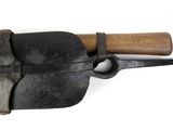 an old tool with a wooden handle hanging on a wall