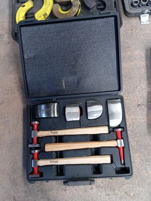 une mallette noire posée par terre, contenant des outils