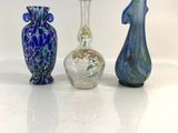 three glass vases sitting on a white surface with a white background