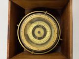une boîte en bois contenant une horloge, accrochée au mur
