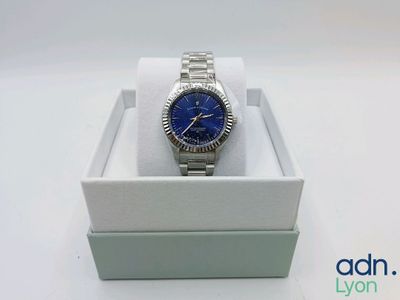gros plan d'une montre dans une boîte sur une surface blanche