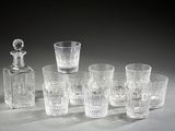 six glasses and a decanter sitting on a table