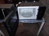 a microwave that is sitting on a table next to a microwave oven