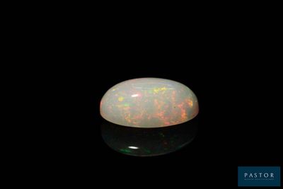 a white oplite stone on a black surface