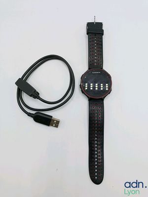 the watch is connected to a charger and a usb cable