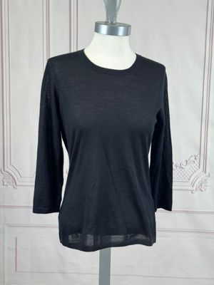 the top of a black shirt is on a mannequin stand