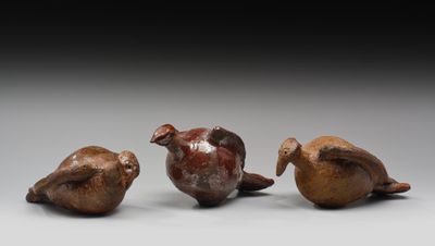 trois petits oiseaux, perchés les uns sur les autres, côte à côte