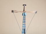 une sculpture représentant une croix, réalisée en bois et en fil de fer