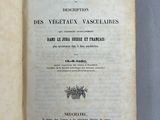un livre ouvert posé sur une table, à côté d'une table bleue