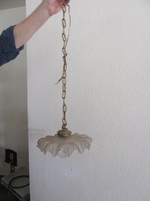 une personne tenant une lampe suspendue à une chaîne