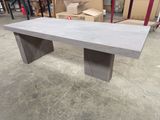une table en béton dans un entrepôt, avec des cartons en arrière-plan