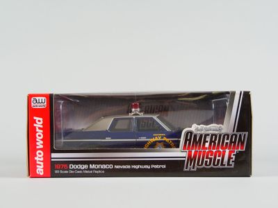 une voiture de police miniature dans une boîte, posée sur une surface blanche