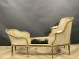 a white wicker chaise sitting on top of a wooden floor