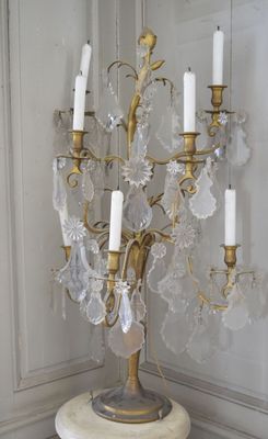 un candélabre en or surmonté d'un bouquet de bougies