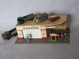 a model of a gas station with cars and a truck
