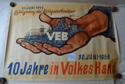 a poster on the wall of a building with a hand holding a model of a building