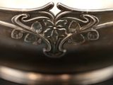 a close up of a silver bowl on a table