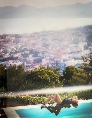 a man diving into a swimming pool with a city in the background