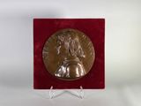 un gros plan d'une médaille posée sur un socle, sur fond blanc