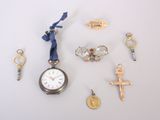 de nombreux breloques et une montre de poche posés sur la table