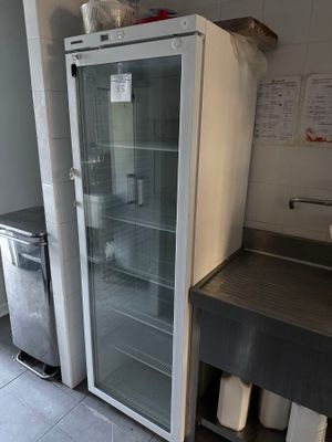 un réfrigérateur avec une porte en verre dans une cuisine