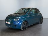 the small blue car is parked in a large room