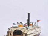 a small model of a boat on a white surface