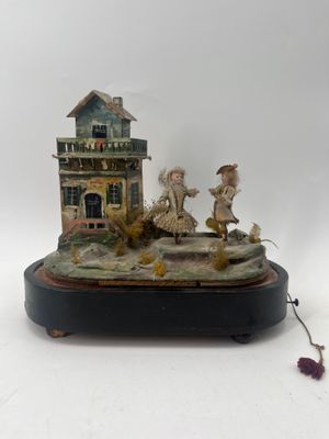 a figurine of a man and a woman in front of a house