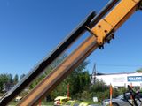 a crane that is lifting a car out of the back of a truck