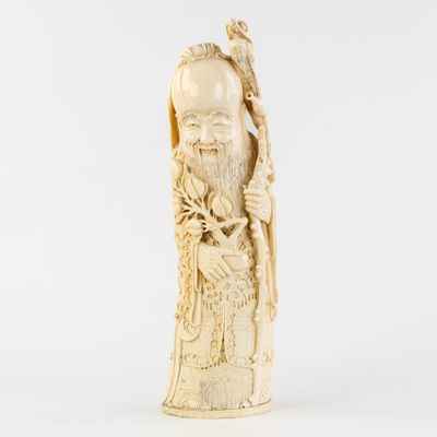 une figurine ancienne en ivoire sculpté représentant un homme tenant un oiseau