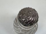 a glass jar with a silver lid sitting on a table