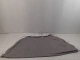 a bed with a gray blanket on it in the corner of a room