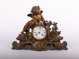 une petite horloge sur laquelle est posé un cheroon