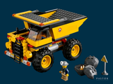 a lego dump truck with a man standing next to it