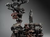 statue représentant un homme debout devant un arbre, entouré d'animaux