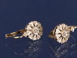 pair of old cut diamond earrings on a blue surface