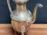 silver plated teapot on wooden table with black background