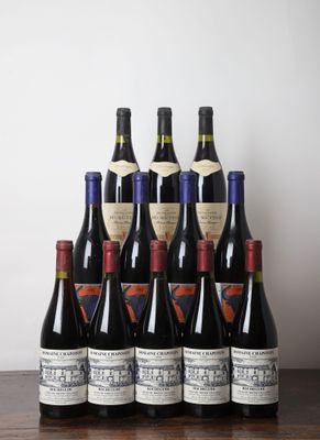 six bouteilles de vin sont posées sur une table devant un mur blanc